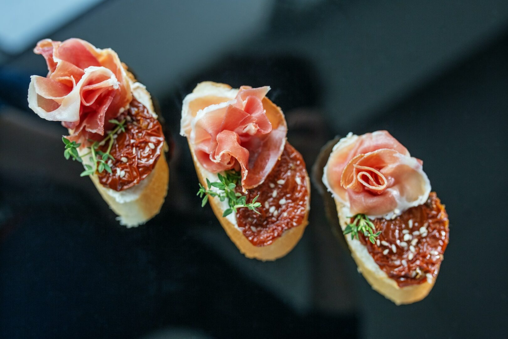 Appetizer with prosciutto, bruschetta and sun-dried tomato. Food, restaurant and event concept.