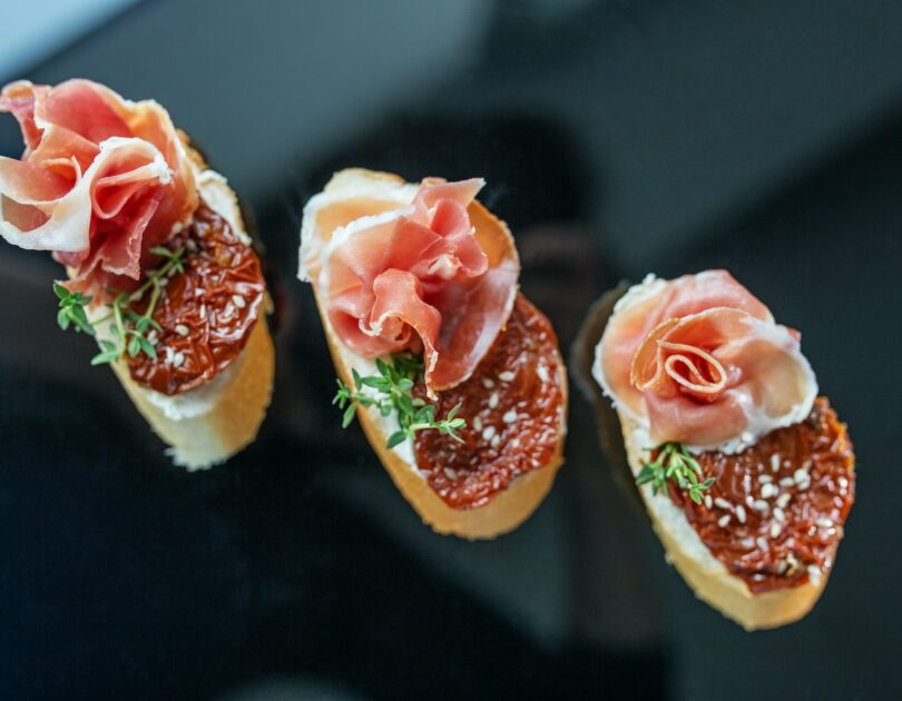 Appetizer with prosciutto, bruschetta and sun-dried tomato. Food, restaurant and event concept.