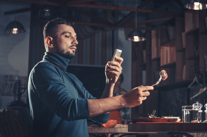 man photographing food