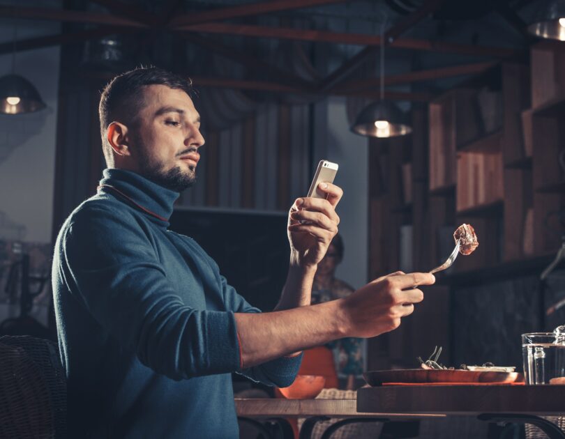 man photographing food