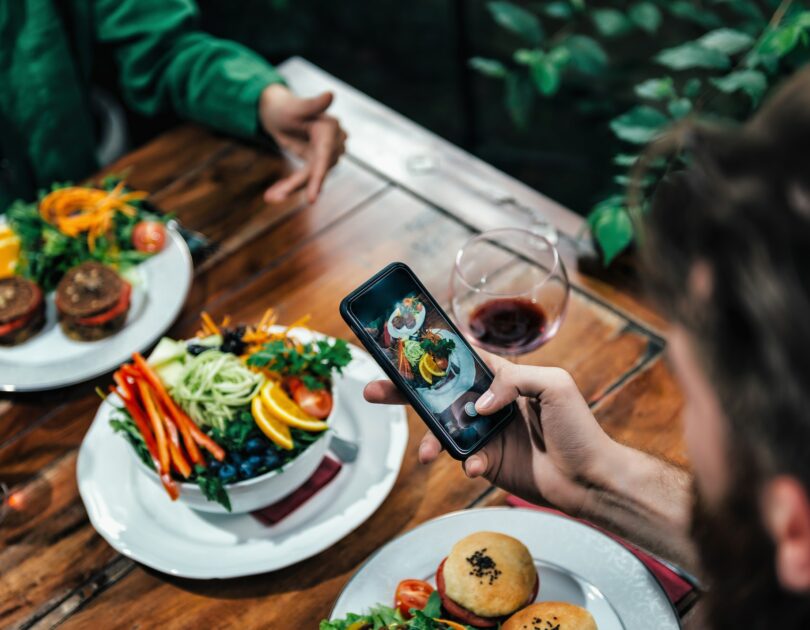 Man Photographing Food In A Restaurant